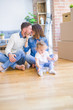 © Krakenimages.com - Beautiful family sitting on the floor playing with his kid at new home around cardboard boxes