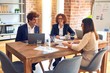 © Krakenimages.com - Group of business workers smiling happy and confident. Speaking with smile on face working together using laptop at the office.