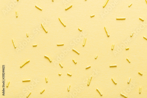 flat lay of sprinkles over yellow background, decoration for banner, poster, ...
