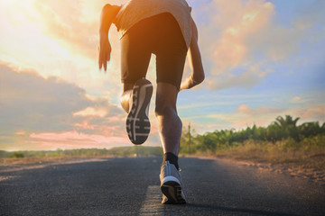 Wall Mural - Young fitness man running at road for exercise.