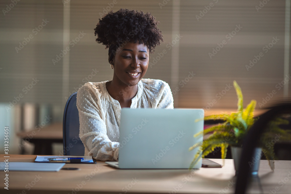 Foto Young black woman in an office smiling to camera, close up ...
