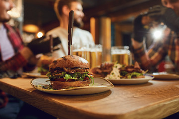 Burger with beer on the table in a bar pub.