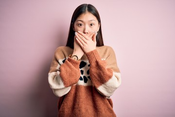 Poster - Young beautiful asian woman wearing animal print fashion sweater over pink isolated background shocked covering mouth with hands for mistake. Secret concept.