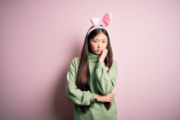 Sticker - Young asian woman wearing cute easter bunny ears over pink background thinking looking tired and bored with depression problems with crossed arms.