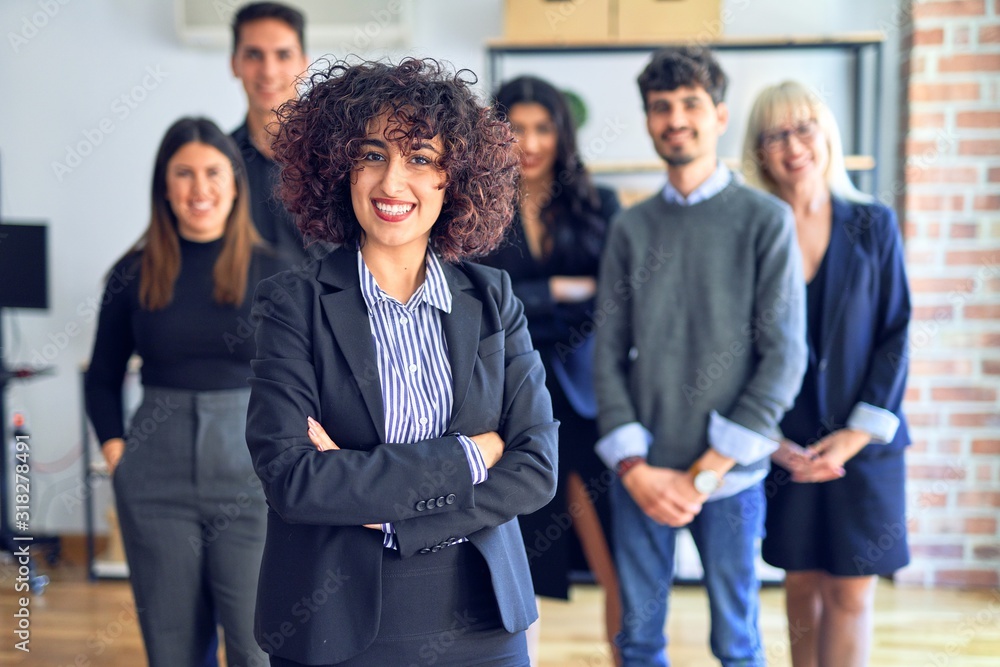 Group of business workers smiling happy and confident. Posing together with smile on face looking at the camera, young beautiful woman with crossed arms at the office