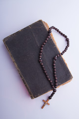 Wall Mural - Old holy bible and rosary necklace. White isolated background.