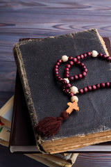 Wall Mural - Old books with rosary beads and wooden cross. Faith and religion concept.