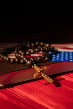 In God We Trust Concept. Rosary With Cross Crucifix Ans Usa Flag On Holy Bible Book.