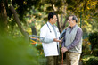 © creativeimages - Doctor talking with senior man in hospital garden