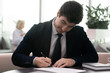 © fizkes - Satisfied with business offer young entrepreneur signing contract.