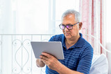 Senior eldery male man holding and using digital tablet