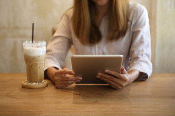 Business woman using tablet with ice coffee in cafe
