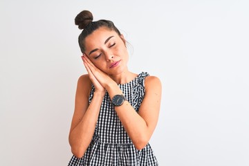 Sticker - Beautiful woman with bun wearing casual dresss standing over isolated white background sleeping tired dreaming and posing with hands together while smiling with closed eyes.