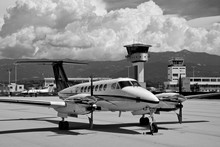 A Private Turboprop Beechcraft Aircraft Parked At Ajaccio Airport On A Black And White Shot With Stormy Clouds And Sky During A Summer Afternoon
