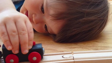 Wall Mural - Toddler boy playing with toy trains