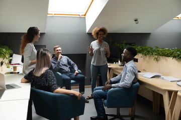 Wall Mural - smiling biracial woman hold teambuilding meeting with colleagues