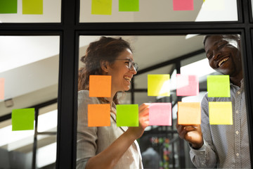 Wall Mural - smiling multiethnic colleagues collaborate project on sticky notes