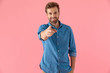 © Viorel Sima - happy casual man in denim shirt smiling and pointing finger