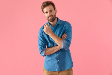 Wall Mural - happy casual man holding elbow in fashion pose and smiling