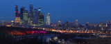 Fototapeta  - Russia, Moscow city Business center skyscrapers with urban buildings, Moscow river turn with painted illuminated trees background, panoramic winter night view from Vorobyovy Gory observation deck