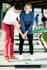 Wall Mural - Golf trainer teaches a woman game