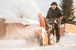 © Parilov - Man cleaning snow from thrower blower machine removal ice storm winter