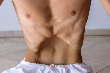 Close-up view of man showing breathing practices of belly, abdominal yoga vacuum exercise