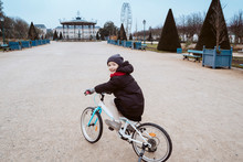 Little Girl Learning How To Ride A Bike For First Time. Family Concept. Teaching Healthy Values In Children. Eco Friendly Transport In European Cities In Winter. Kids Going To School By Bicycle.