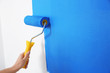 © New Africa - Woman painting white wall with blue dye, closeup. Interior renovation