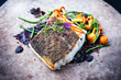 Gourmet fried European skrei cod fish filet with glasswort, fungi and algae as closeup on a modern design plate