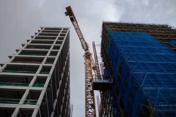 construction crane between unfinished multi-storey buildings bottom view