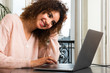 © mimagephotos - smiling young african american woman looking at laptop computer screen