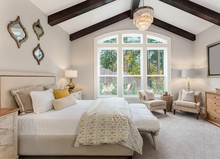 Beautiful Furnished Master Bedroom Interior In Luxury Home . Features Vaulted Ceiling With Wood Beams And Chandelier.