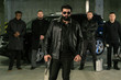 © pressmaster - Bearded criminal authority in sunglasses, black leather jacket and jeans