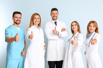 Canvas Print - Team of doctors showing thumb-up gesture on color background