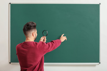 Sticker - Male teacher with magnifier near blackboard in classroom