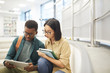 © Seventyfour - Portrait of two international students reading books together while working on project in modern college library, copy space