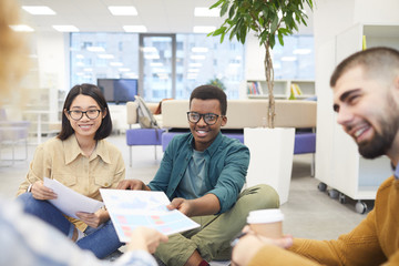 Wall Mural - Multi-ethnic group of students smiling cheerfully while working on project in college library, copy space