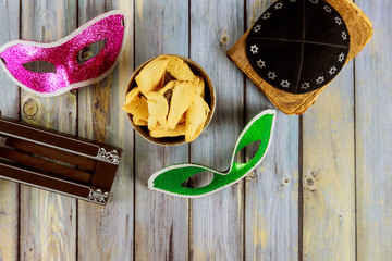 Traditional jewish carnival holiday Purim celebration and hamantaschen cookies, noisemaker and mask, holy book, talit, kippa