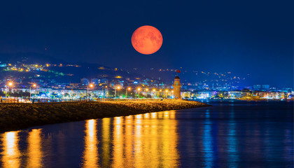 Wall Mural - Lighthouse in the port of Alanya with full moon at twilight blue hour - Alanya, Turkey 