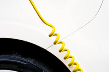 Cropped Image Of Electric Car With Yellow Cable