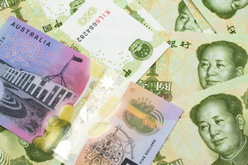 A close up image of an Australian five dollar bill with Chinese one yuan bank notes in macro