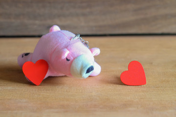 Wall Mural - Red hearts with pink bear toy on wood table.