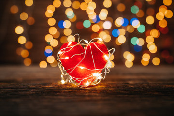 Wall Mural - Red heart shape covered led lights on wooden and bokeh lights background. Valentines day and romance concept.