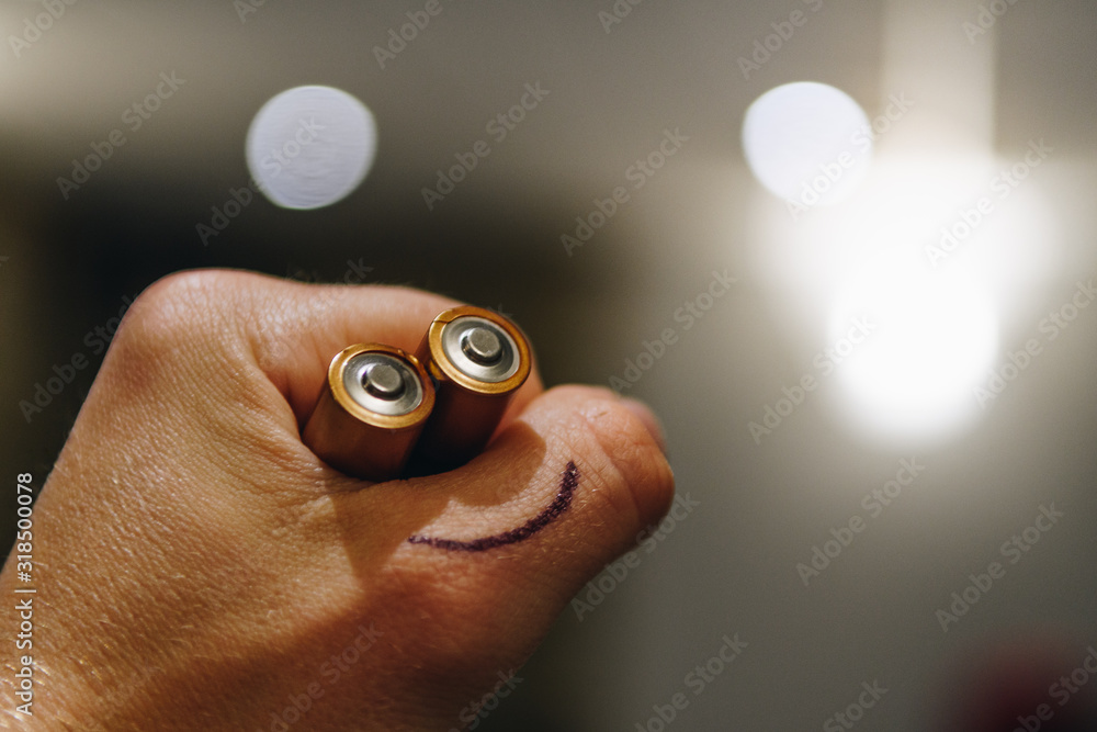 Cropped Hand Of Person Holding Batteries With Smiley Face - obrazy, fototapety, plakaty 