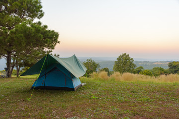 tourist tent on among meadow in the sunset overlooking mountains. outdoors camping