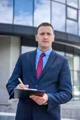 Wall Mural - Agent posing with clipboard against new house