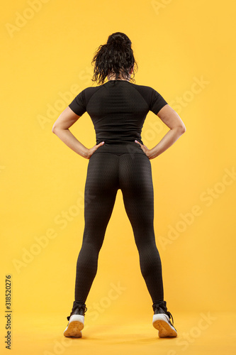 Fotografía Size plus woman sporty fit woman in sportswear, athlete makes fitness exercising on yellow background