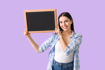 Wall Mural - Young woman with chalkboard on color background