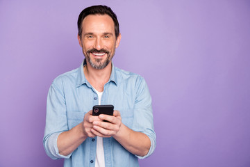 portrait of positive cheerful man use cell phone have rest relax text type sms chatting with friends